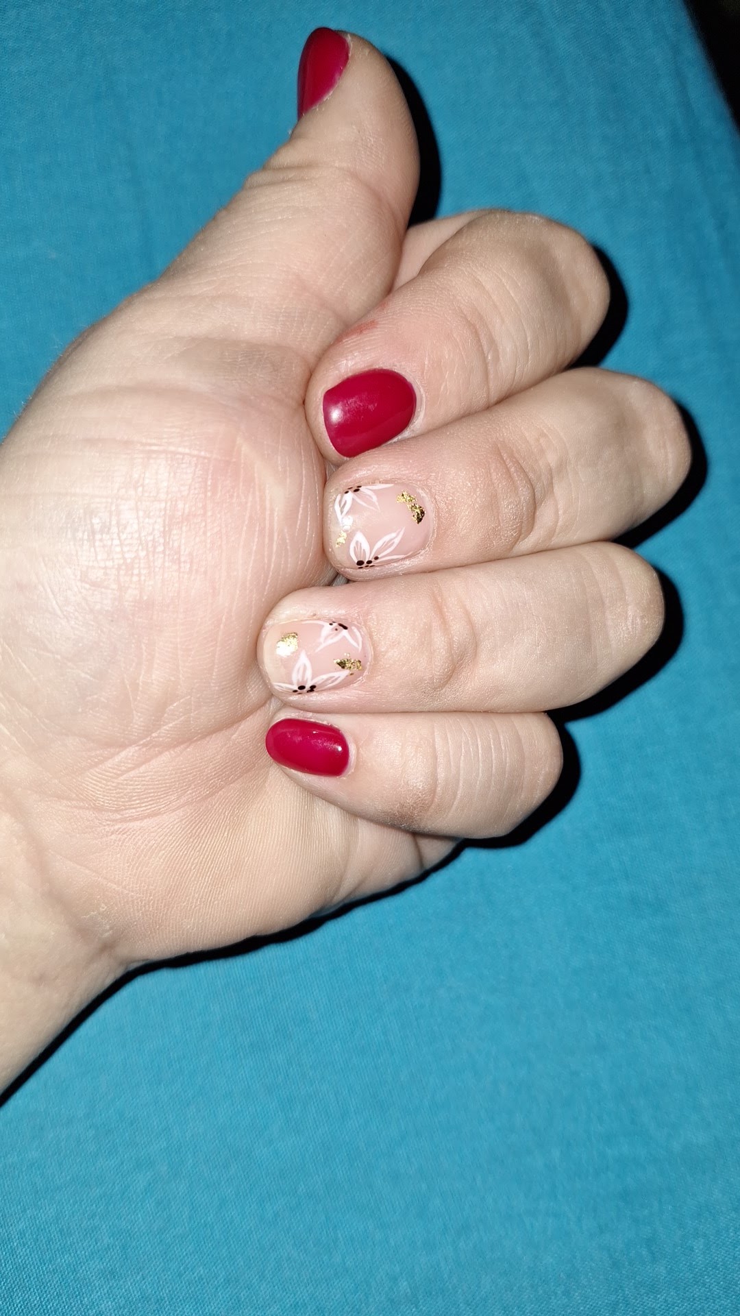 Manicura roja con detalles florales en Nahir Yaya Beauty y Spa